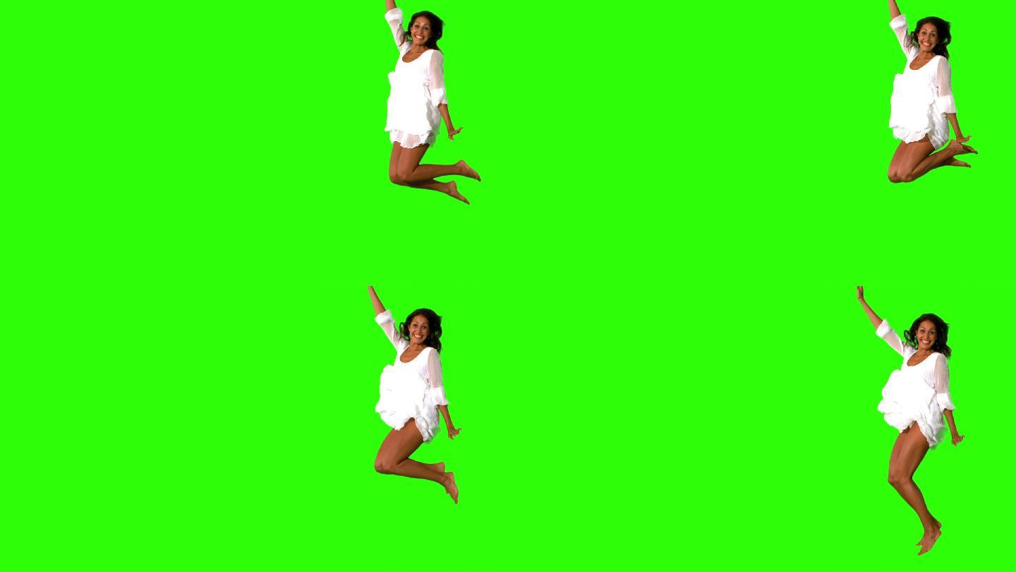 穿白裙子的女孩在绿色屏幕上跳的慢动作