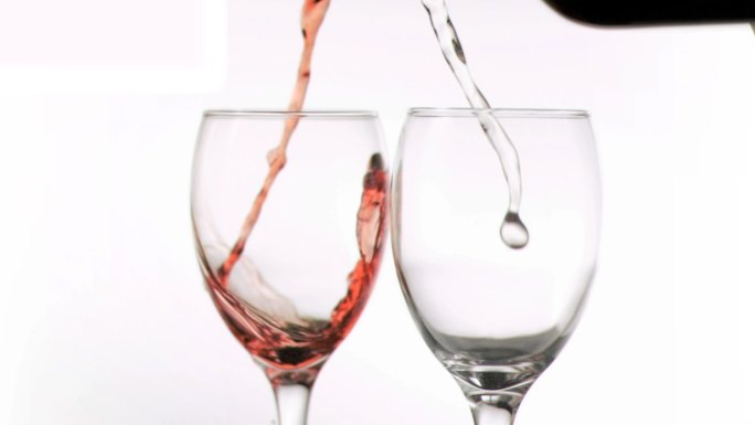 红酒和白葡萄酒以超慢的动作倒进玻璃杯