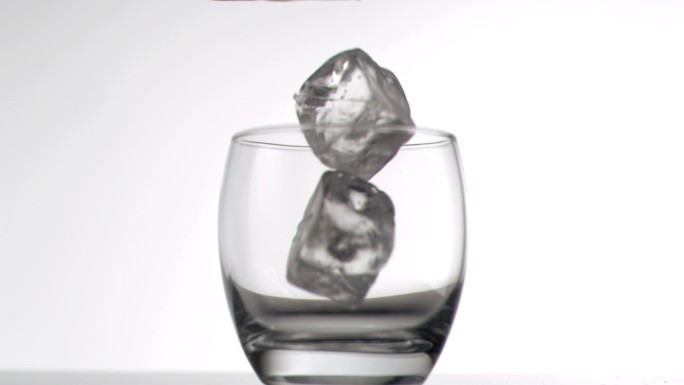 冰块落入玻璃杯慢镜头，在白色背景下