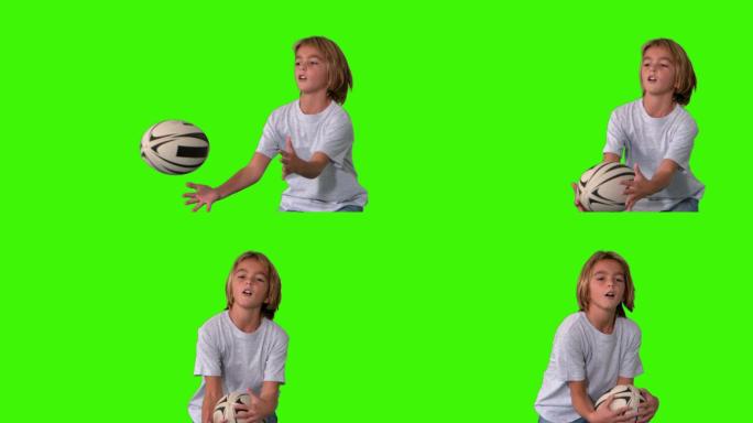 一个男孩在绿色屏幕上用慢镜头接住橄榄球