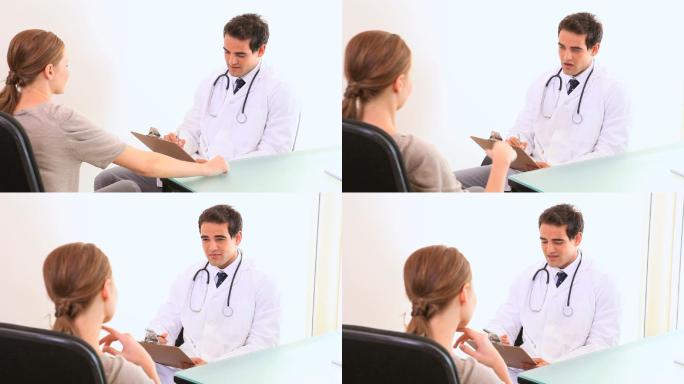 医生一边和病人谈话一边在他的写字板上写下信息