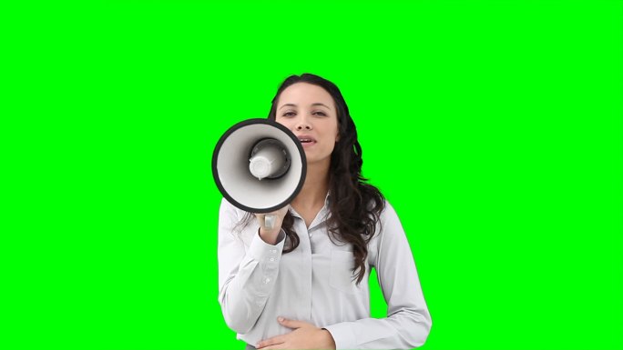 一个女人在绿色背景下对着扩音器说话