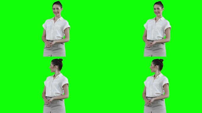 在绿色背景的映衬下，一个女人微笑着看着摄像机