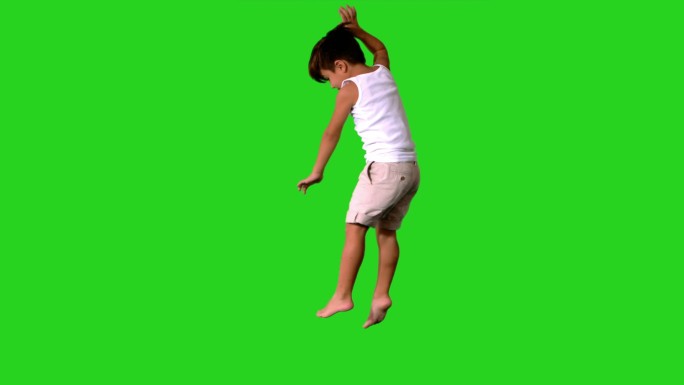 快乐的小男孩在绿色屏幕上跳跃和旋转的慢动作