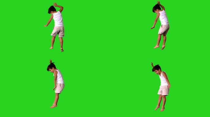 快乐的小男孩在绿色屏幕上跳跃和旋转的慢动作