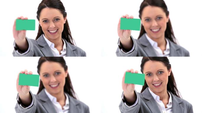 一个黑发女性拿着一张绿色卡片，在白色背景下