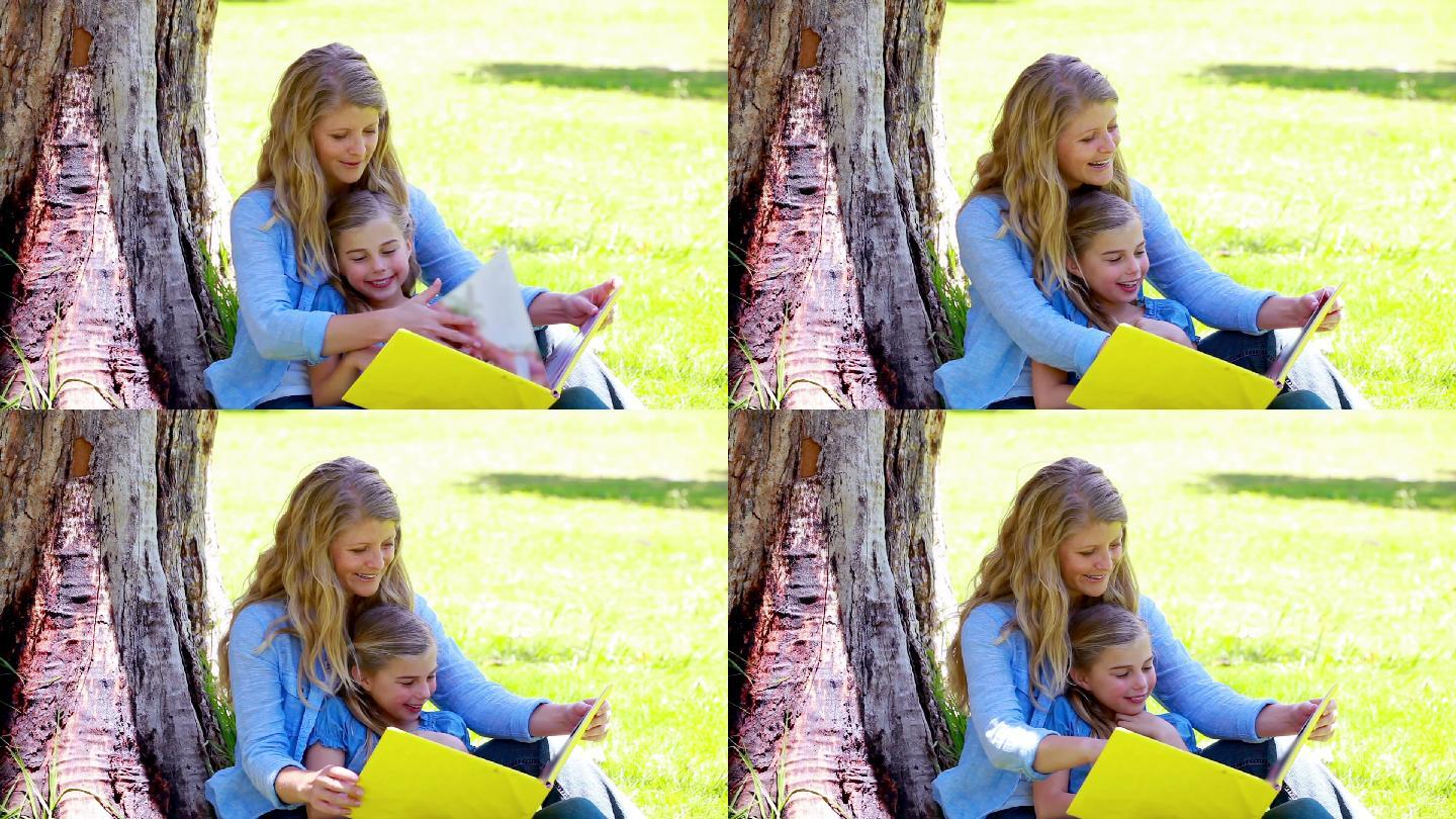 女儿和妈妈在公园里看图画书
