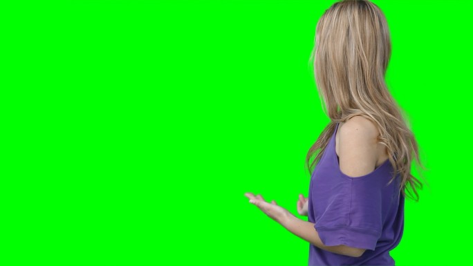 一个女人在绿色背景下炫耀着一些虚拟的东西