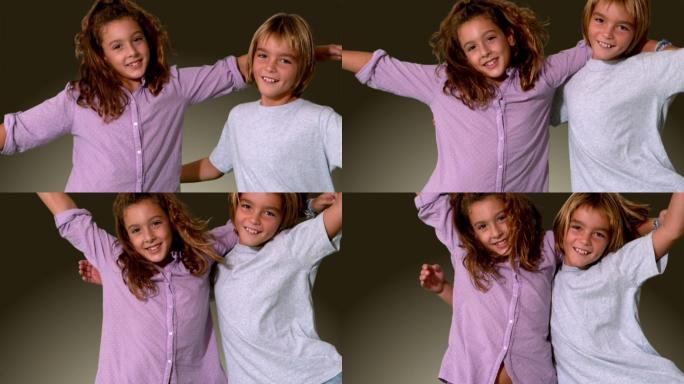 哥哥和妹妹跳进同一个镜头，拥抱在灰色背景的慢动作