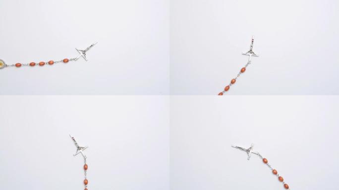 十字架上的珠子旋转白色表面视频