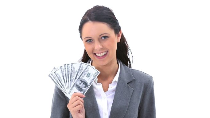 女商人微笑着拿着美国钞票对着白色的背景