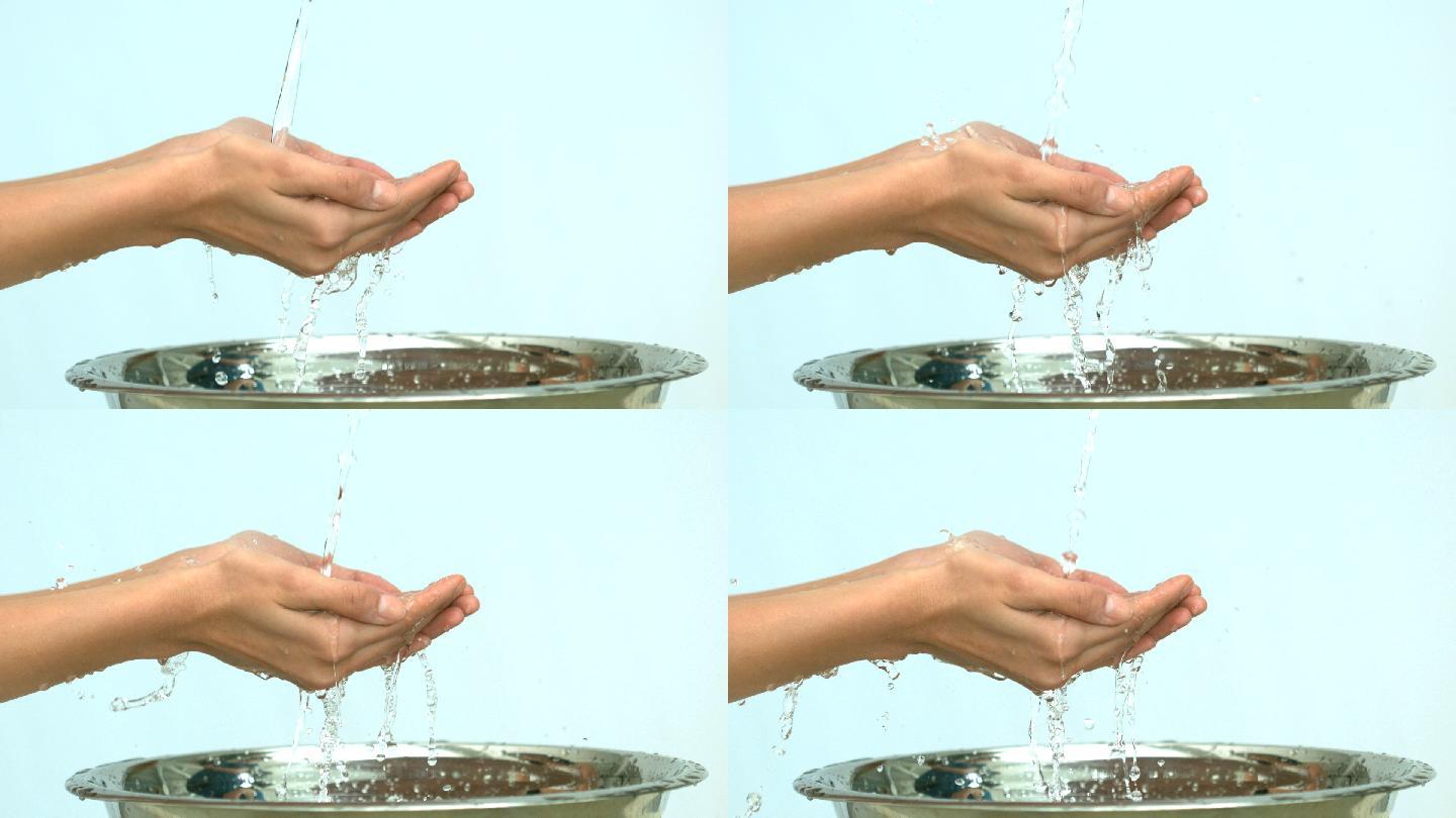 一名妇女在水槽的水流下慢动作洗手