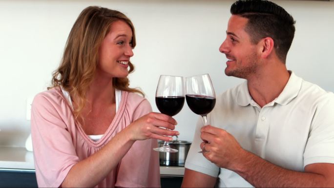 幸福的夫妇在厨房喝红酒的慢镜头
