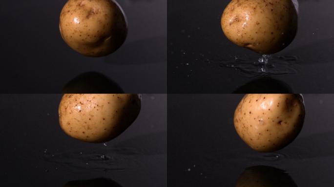 土豆落在潮湿的黑色背景慢镜头
