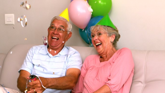 一对老年夫妇在沙发上慢镜头庆祝生日