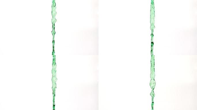 在慢镜头中，绿色的水从白色的背景中倾泻而过