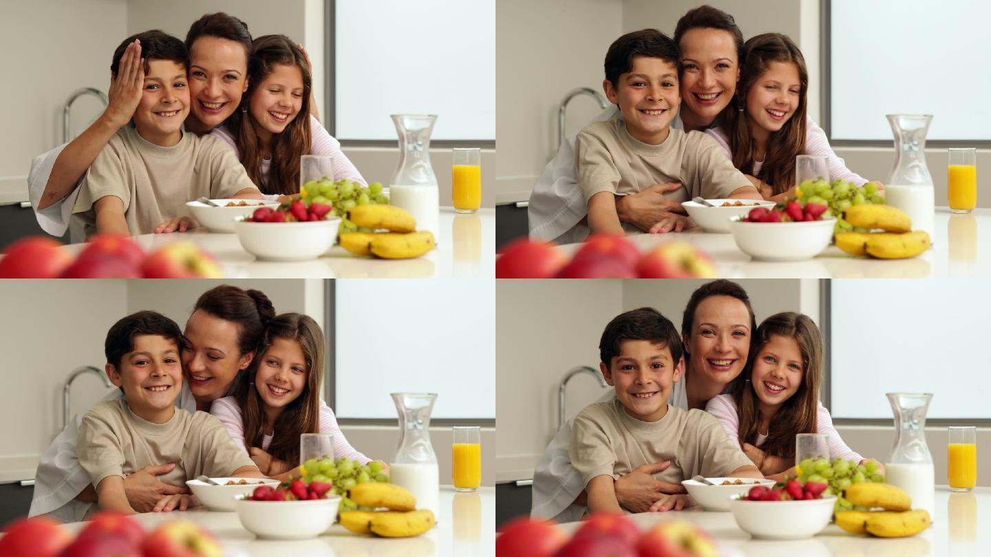 快乐的母亲和她的孩子们在厨房里吃早餐