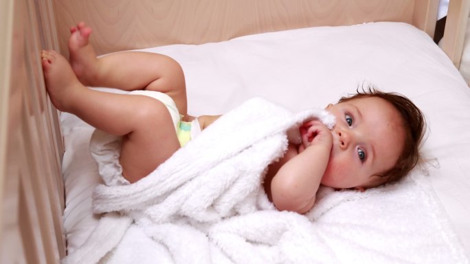 穿着尿布的婴儿躺在卧室的婴儿床上