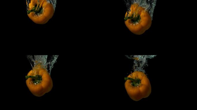 在黑色背景的慢镜头中，黄椒落在水中