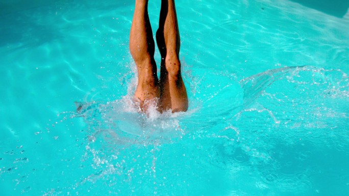 运动游泳运动员以慢动作跳入游泳池