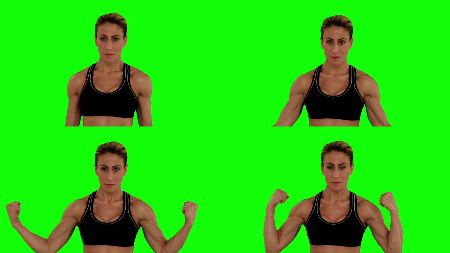 超级健康的女人弯曲她的手臂在绿色的屏幕背景