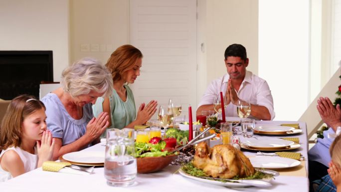圣诞晚餐前，家人在餐厅里祈祷