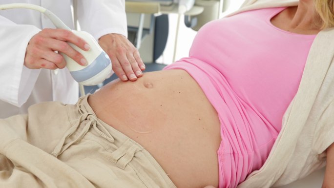 一名金发孕妇正在医院的办公室里做超声波扫描