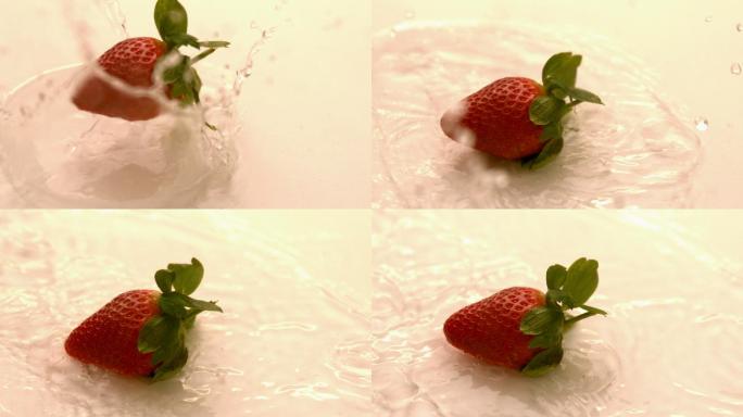 草莓以慢镜头落在白色潮湿的表面上
