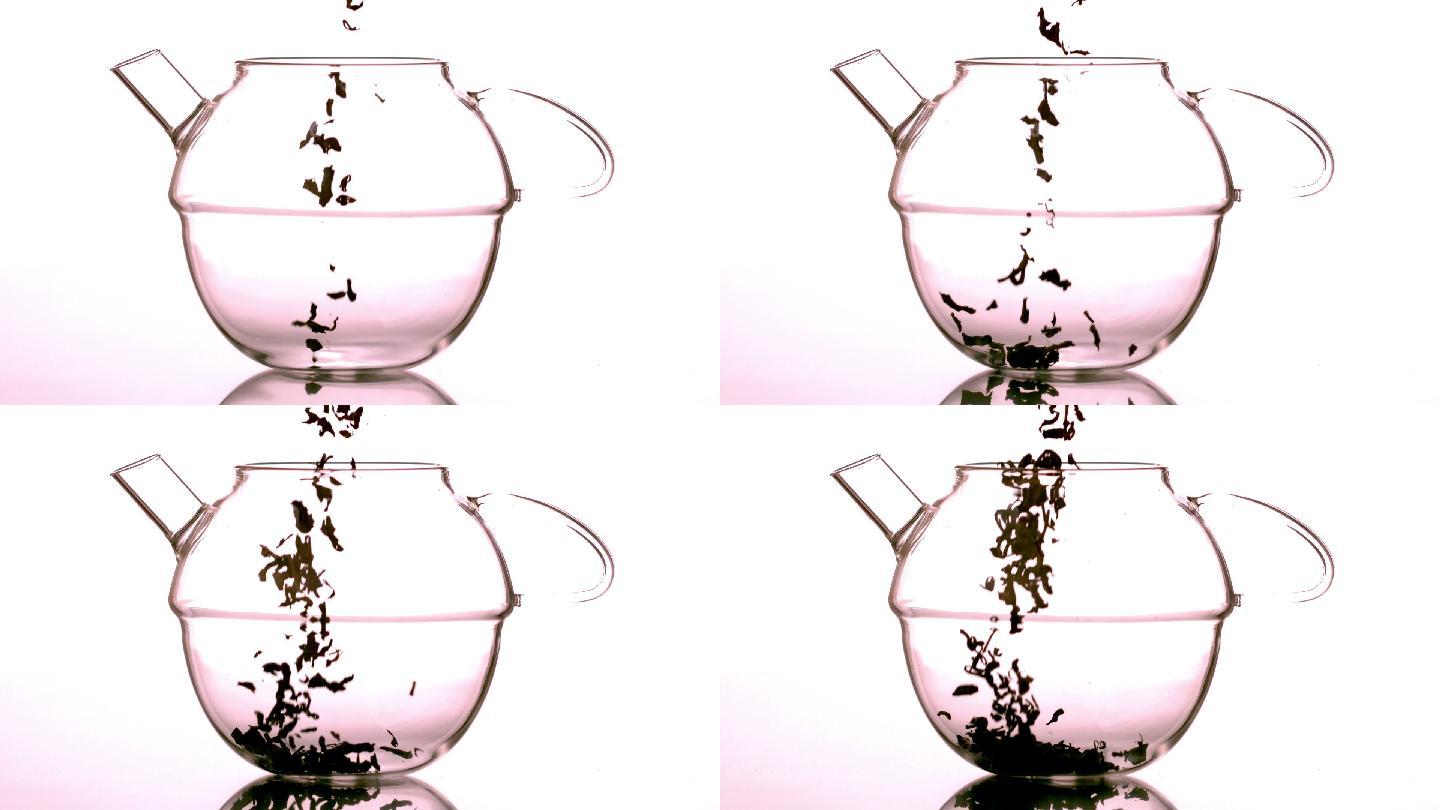 松散的花草茶在慢动作中落入玻璃茶壶