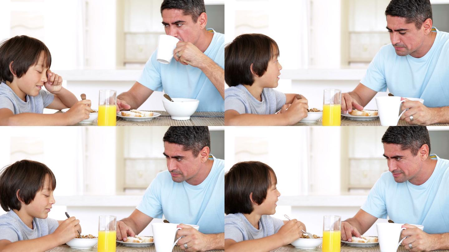 一个男人和他的儿子在厨房里吃早餐聊天