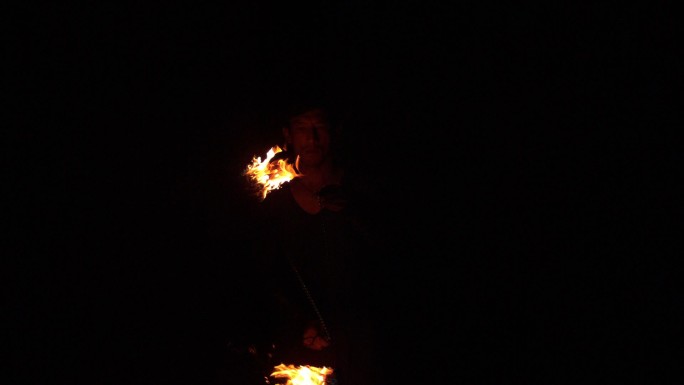 火焰舞者用慢动作在黑暗中划出火焰的痕迹