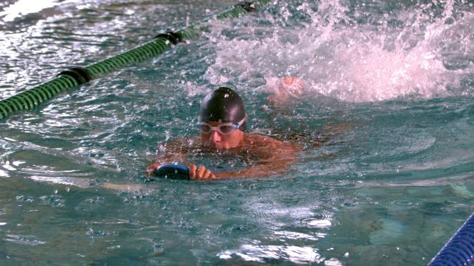 肌肉发达的游泳健将慢动作在游泳池中游泳