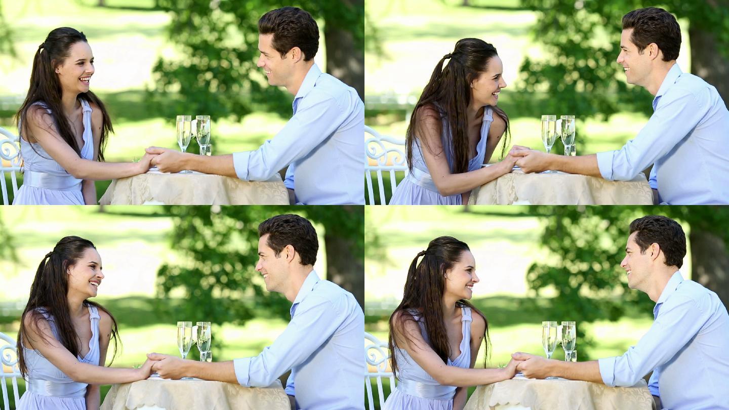 一对情侣在一个阳光明媚的日子里一起在外面吃一顿浪漫的晚餐