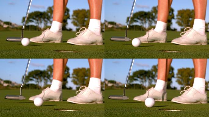 女高尔夫球手把高尔夫球放在果岭上的慢动作