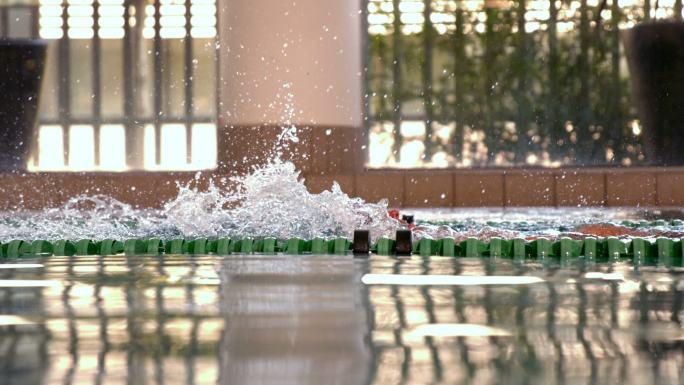 健康的游泳者在游泳池中用慢动作做仰泳