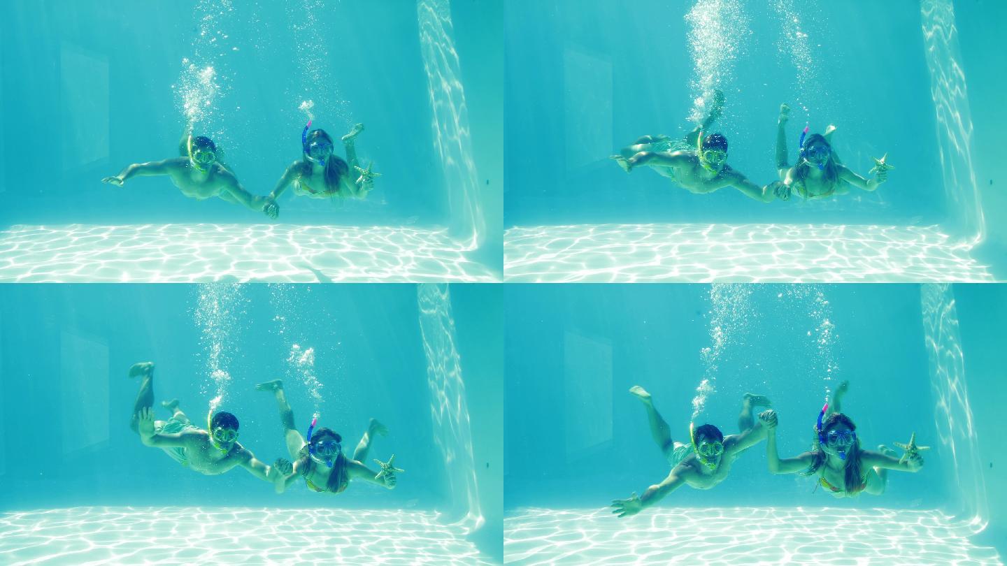 一对快乐的情侣穿着潜水管，手拿海星，跳进游泳池度假