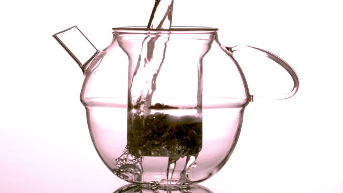 慢动作水倒在茶壶里的散茶上