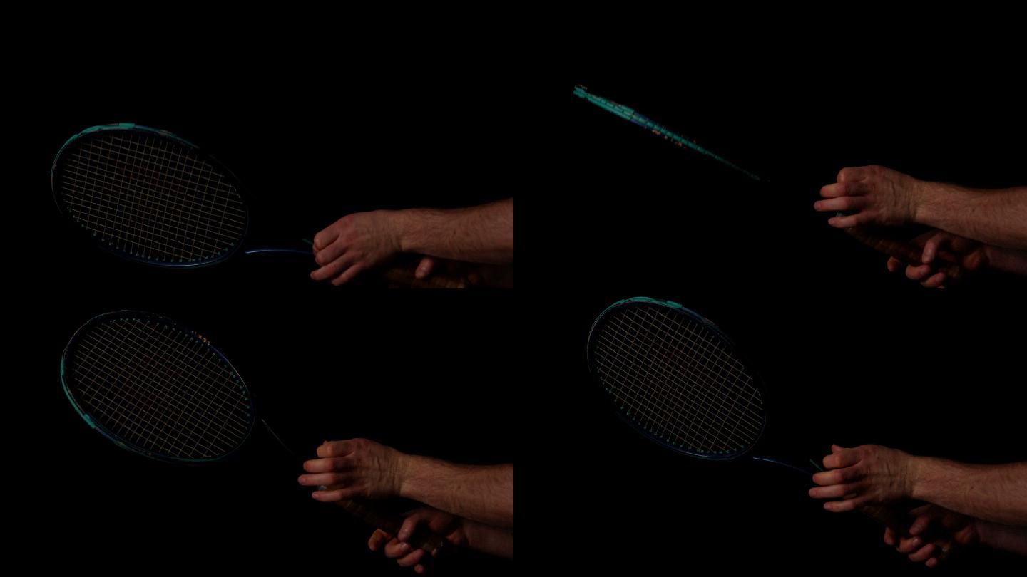 用手在黑色背景慢动作旋转网球拍