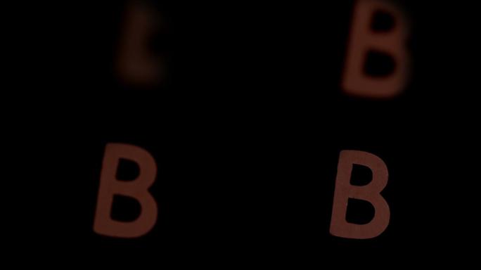 在慢镜头中，字母b在黑色背景上上升