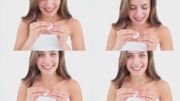 在白色背景下，微笑的女人用洗甲水