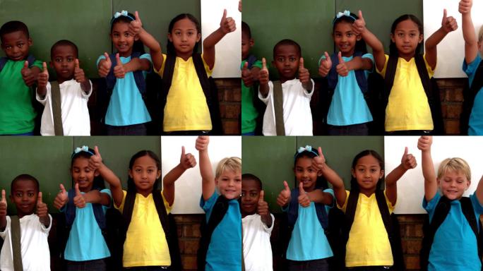 可爱的小学生在教室里用慢动作竖起大拇指