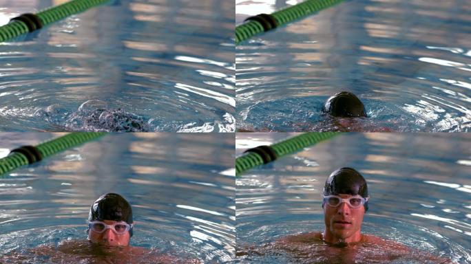肌肉发达的游泳健将以慢动作从泳池中出现