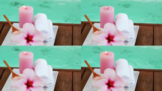 浴巾，蜡烛，还有水疗池边的粉色花朵