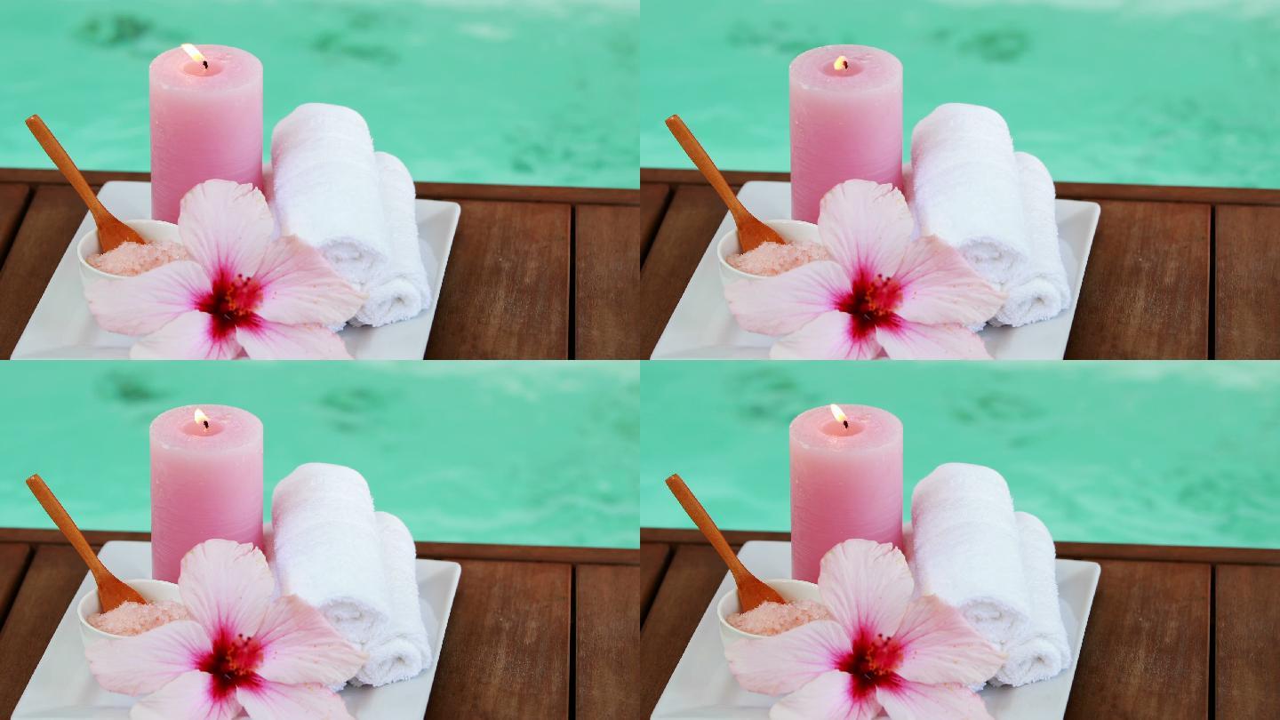 浴巾，蜡烛，还有水疗池边的粉色花朵