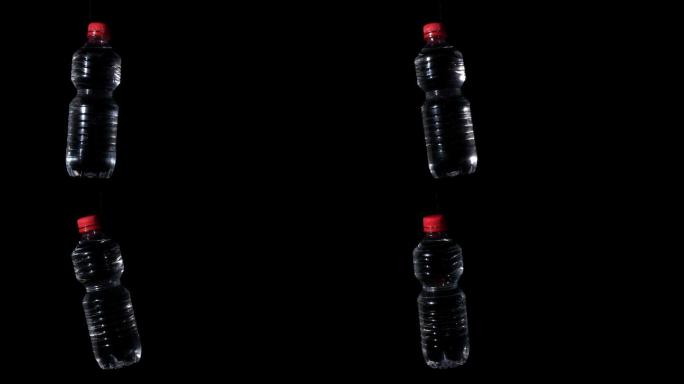 塑料瓶在黑色表面慢动作旋转