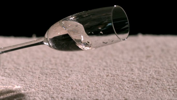 慢镜头中，一杯水洒在地毯上