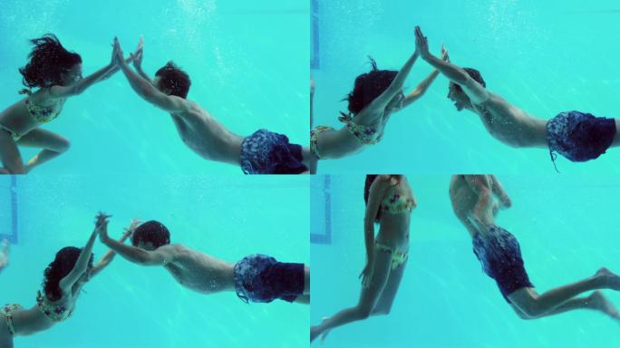 幸福的夫妇在他们的假期里手牵手一起跳进游泳池