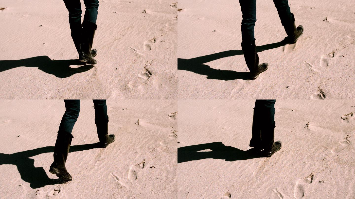 穿着靴子在沙滩上慢镜头行走的女人