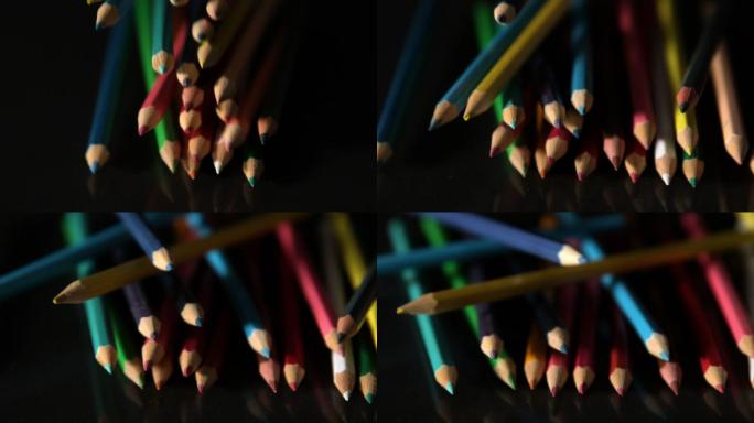 彩色铅笔缓慢地落在黑色的表面