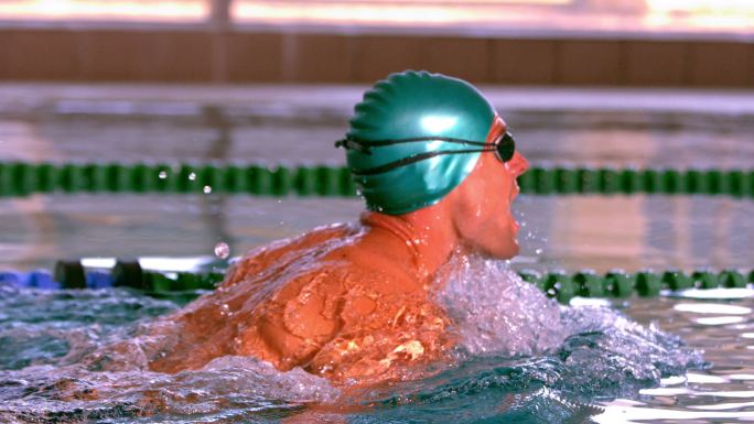 健康的游泳运动员在游泳池做蛙泳的慢动作